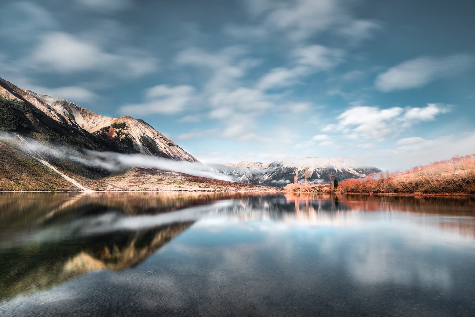 landscape photo of mountains, water and clouds, the clouds are reflecting in the water